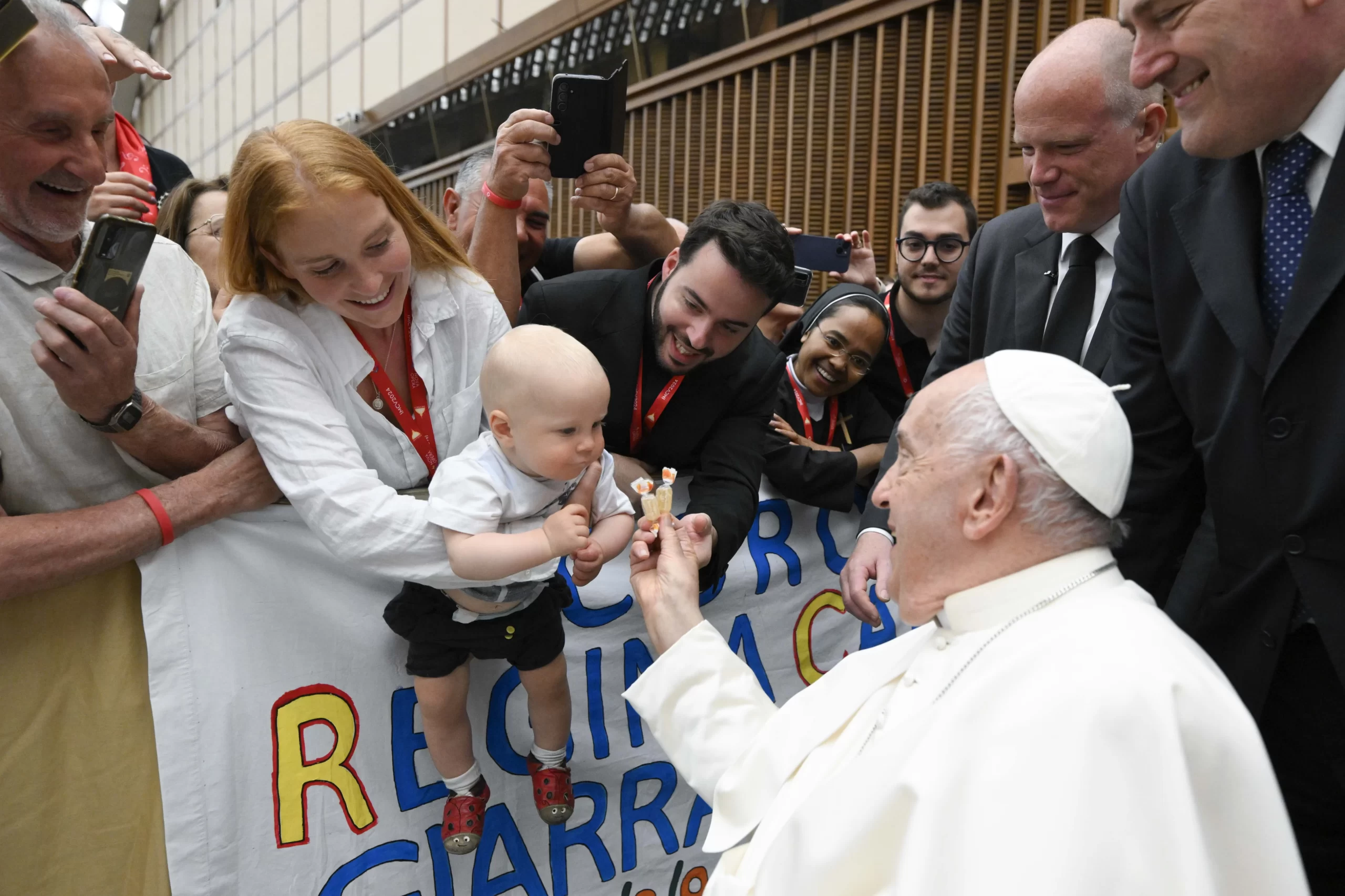 Sweet! Pope Francis visits with a baby in the Vatican's Paul VI Hall on June 8 during a meeting with choir members. Credit: Vatican Media