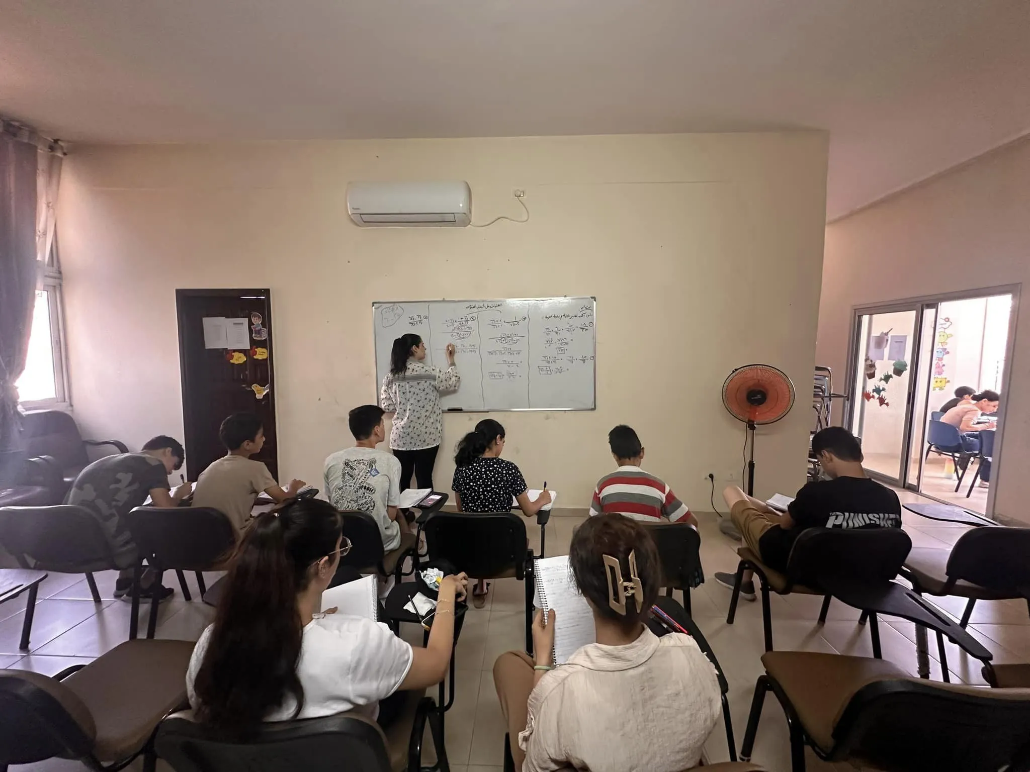 A group of teenagers from Gaza engages in school review activities. Every day, from 10 a.m. to 1 p.m., small review lessons are held on key subjects: mathematics, Arabic, science, and English. It is not a typical school, and there are no formal curricula to follow. The idea is rather to help the young people channel their physical and mental energy into something constructive and to be ready for when school resumes. “Because this war will end one day, and we will be ready to start again,” said Father Gabriel Romanelli, the parish priest, with conviction. Credit: Photo courtesy of Father Gabriel Romanelli