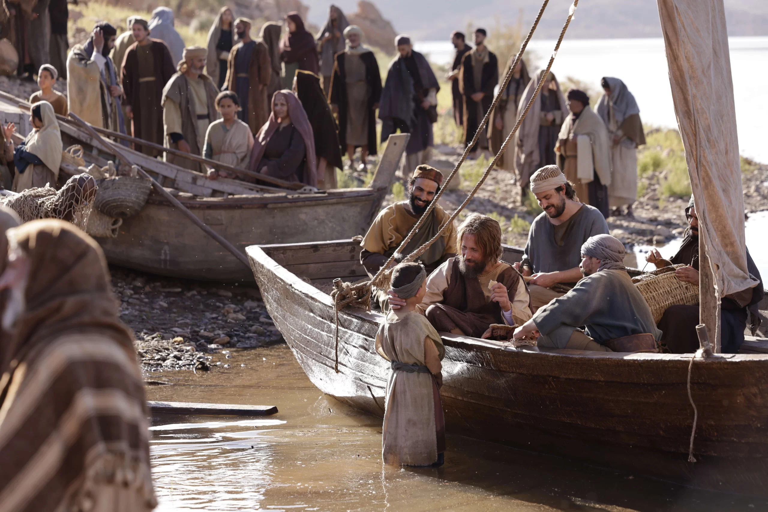 The disciple Peter speaking with a young boy as he sits in a fishing boat in the new film "The Last Supper." Credit: The Last Supper movie