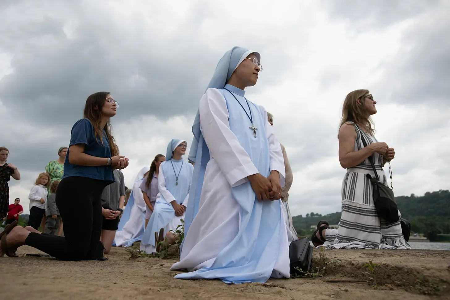 The faithful kneel before the Blessed Sacrament as it processes aboard the vessel "Sewickley" on the Ohio River near Steubenville, Sunday, June 23, 2024. Credit: Jeff Bruno