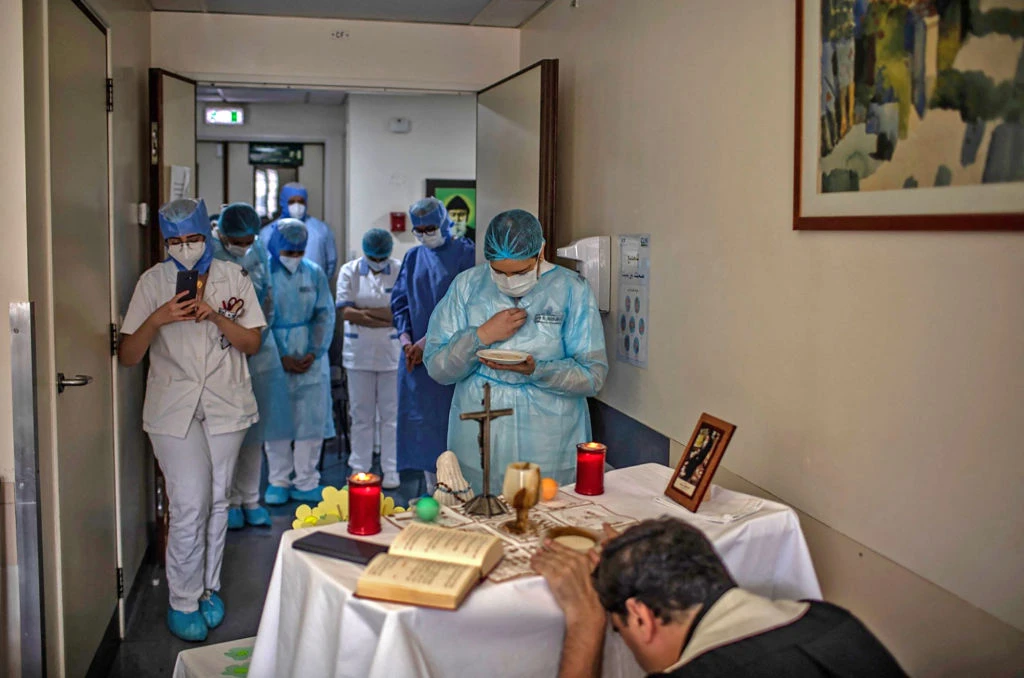 Health care staff attend Mass at the Hotel Dieu de France Hospital on May 8, 2020, in the COVID-19 section of the hospital located in the eastern suburbs of Beirut, Labanon. Credit:  Hotel Dieu de France Hospital/AFP via Getty Images