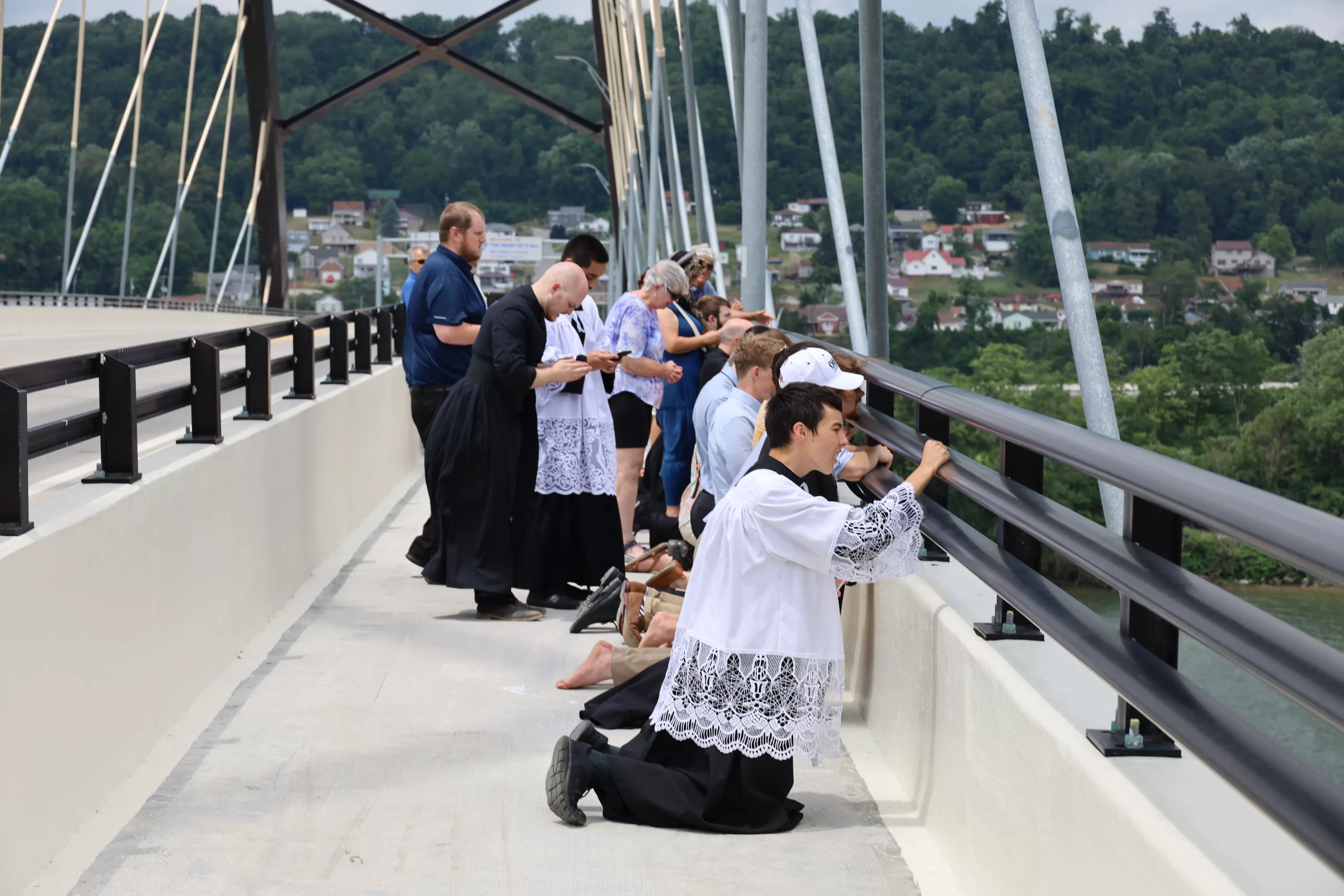 Pilgrims pray as the Blessed Sacrament passes aboard the vessel ‘Sewickley' on the Ohio River near Steubenville, Sunday, June 23, 2024. Credit: Colleen Rowan