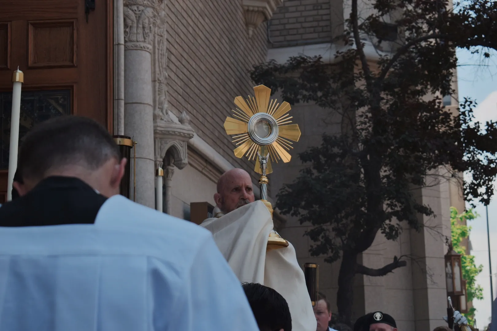 Archbishop Samuel Aquila blesses the crowd of processors as they stand and kneel outside Holy Ghost Church at the end of the Eucharistic procession in Denver on June 9, 2024. Credit: Kate Quiñones/CNA