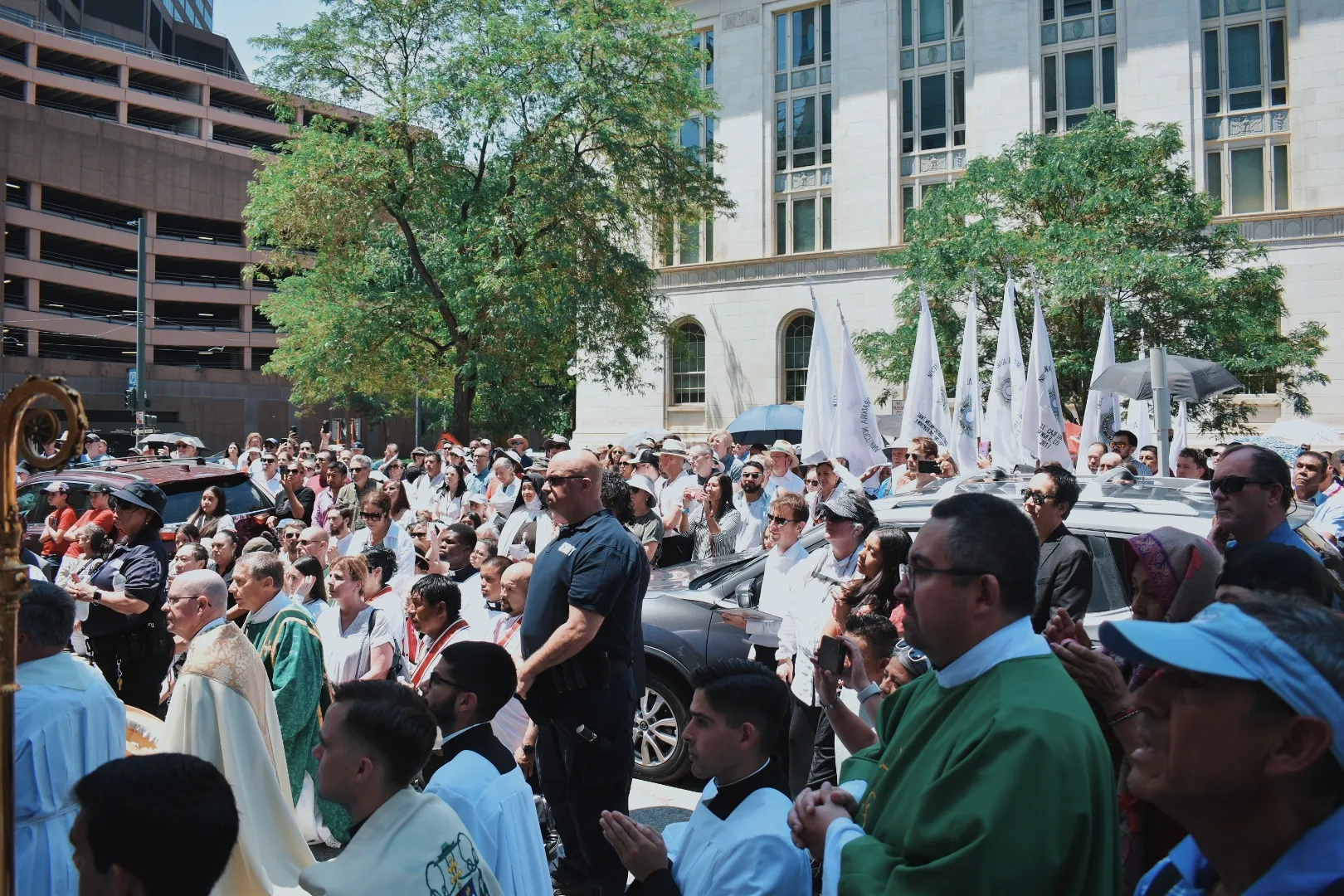 The crowd following the Eucharistic procession stands and kneels outside Holy Ghost Church in Denver at the end of the procession on June 9, 2024. Credit: Kate Quiñones/CNA