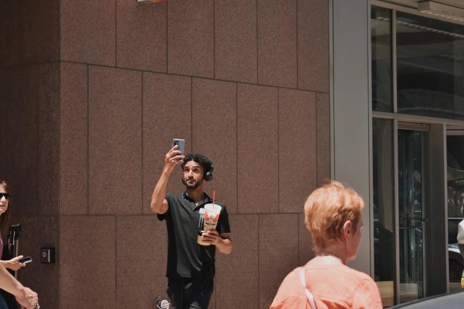 An onlooker takes a photo of the Eucharistic procession in downtown Denver on June 9, 2024. Credit: Kate Quiñones/CNA