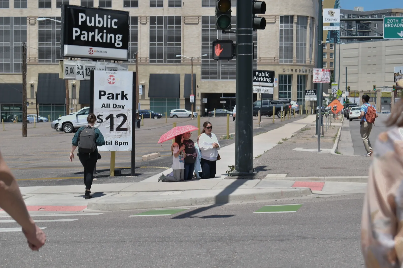 Three women kneel and pray as the Eucharistic procession goes up Broadway in Denver on June 9, 2024. Credit: Kate Quiñones/CNA