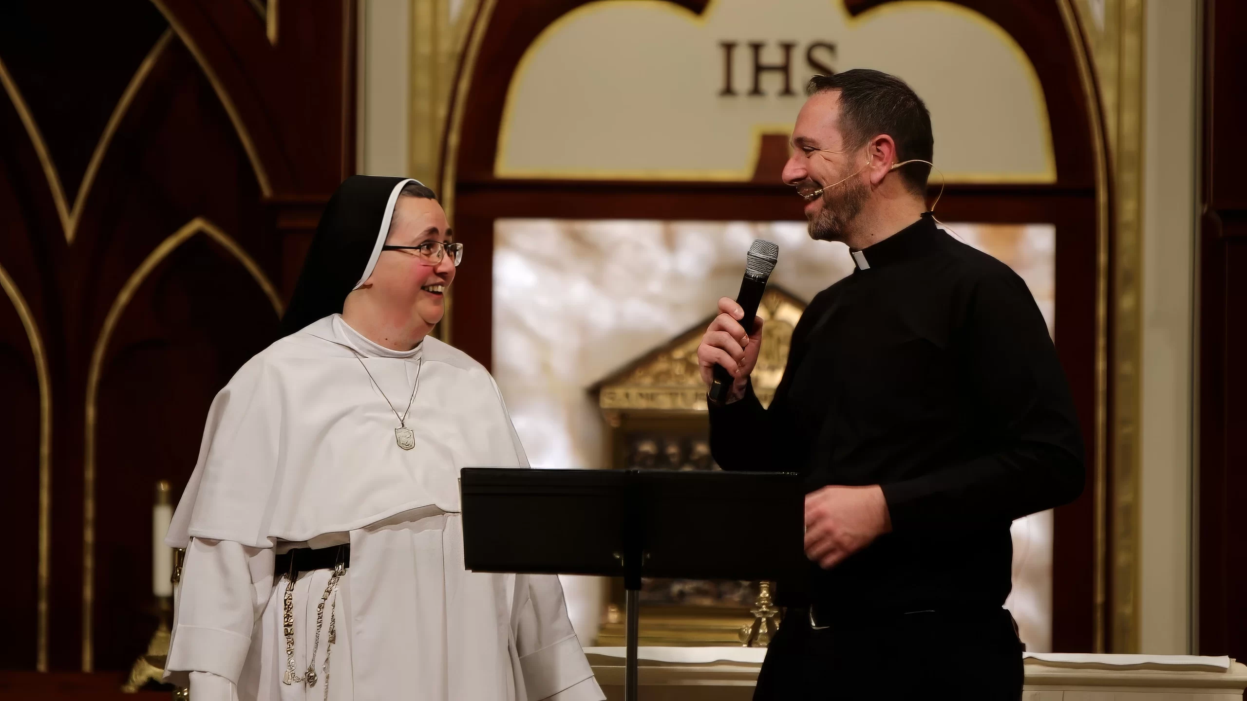 Father Mathias Thelen receives testimony from a religious sister experiencing relief from stiffness in her arm following radiation. Credit: Photo courtesy of Jessica Morehead