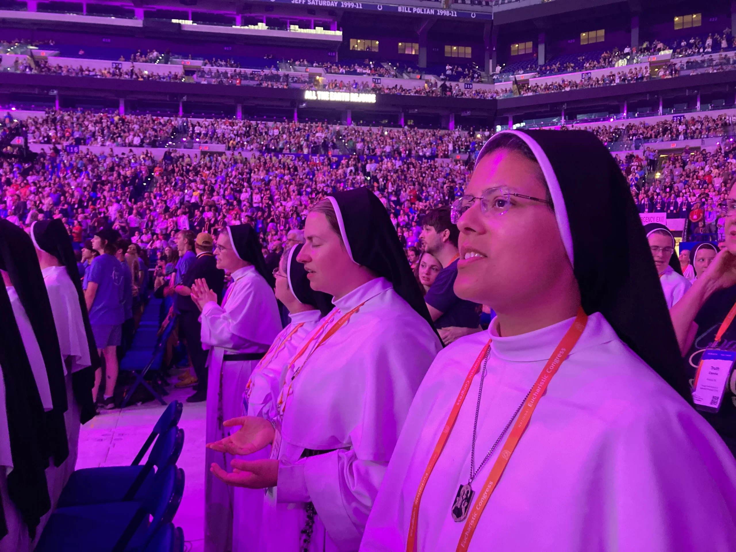 Mother Amata Veritas, OP, Sr. Hyacinth, OP, Sr. Irenaeus, OP, and Sr. Agnes Maria, OP praying in Lucas Oil Stadium at the 2024 National Eucharistic Congress in Indianapolis, Indiana. July 2024. Courtesy of the Dominican Sisters of Mary Mother of the Eucharist