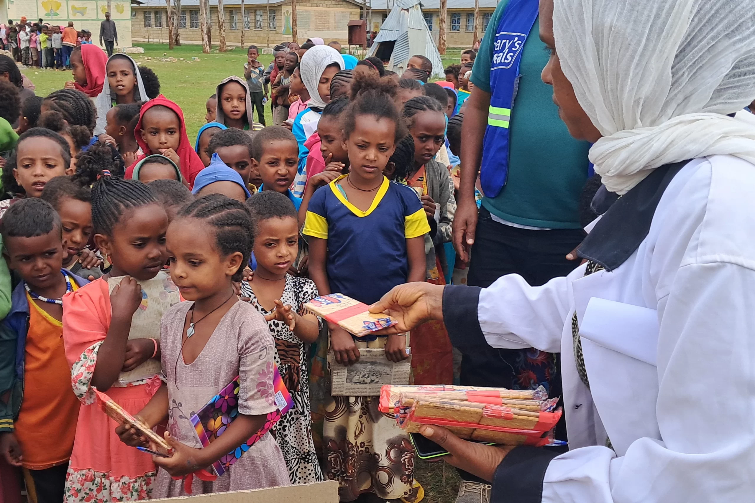 Schoolchildren in Tigray, Ethiopia, eat biscuits and tea provided by Mary's Meals. Credit: Copyright Mary’s Meals