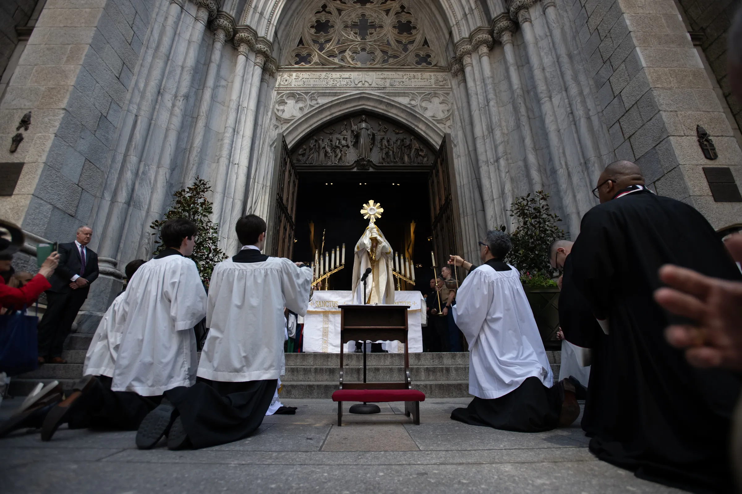 Cardinal Timothy Dolan of New York holds the Eucharist aloft as he blesses pilgrims outside the entrance to St. Patrick's Cathedral in New York City on May 26, 2024. The landmark church was a stop on National Eucharistic Pilgrimage. Credit: Jeffrey Bruno/CNA