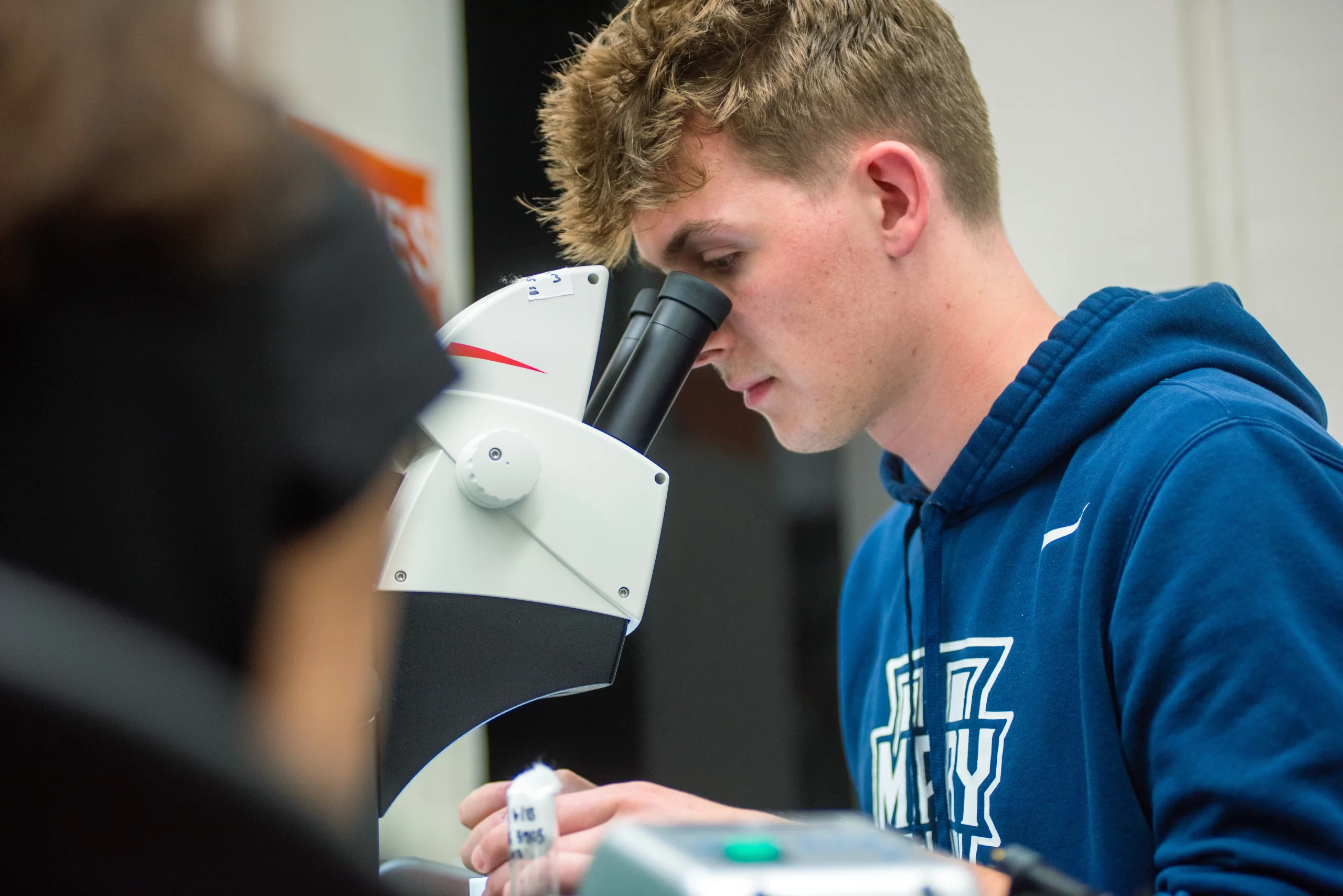 University of Mary SURVE student Austin Link gets a closer look at the eye of a live fruit fly under the microscope. Credit: Mike McCleary/University of Mary